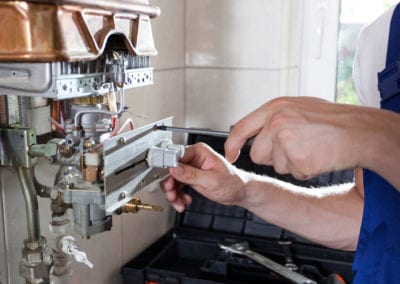Handyman adjusting gas water heater