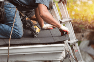 technician installs a roof shingle